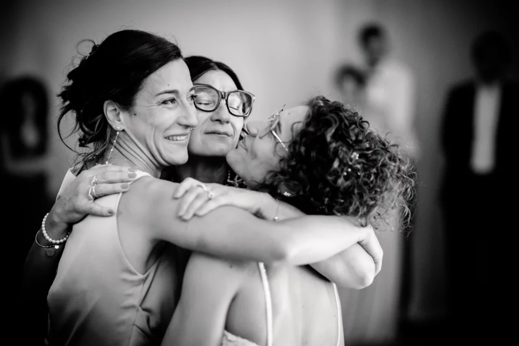 un abbraccio pieno di emozione tra la mamma la sorella e la sposa